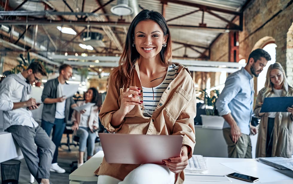 Une femme assise dans un bureau avec son ordinateur portable.