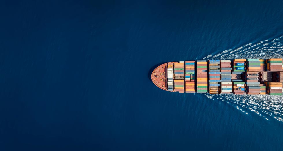 Vue aérienne de haut en bas d'un grand cargo porte-conteneurs en mouvement